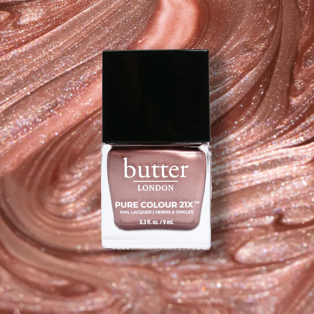 Butter London nail polish bottle on a glittery pink background