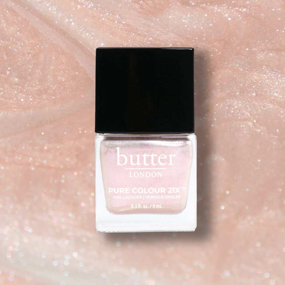 Butter London nail polish bottle on a glittery pink background