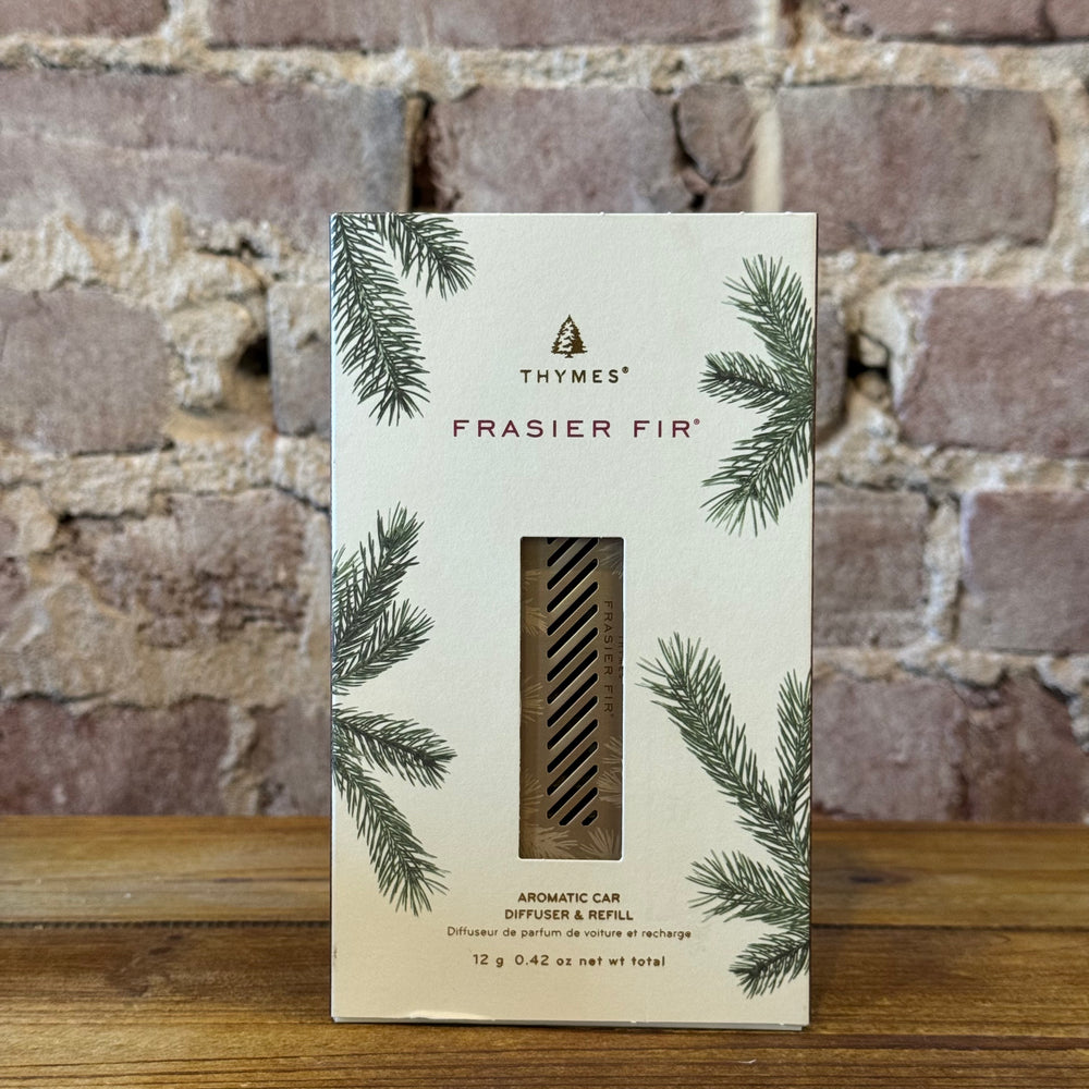 Thymes Frasier Fir automatic car diffuser and refill packaging against a brick wall background